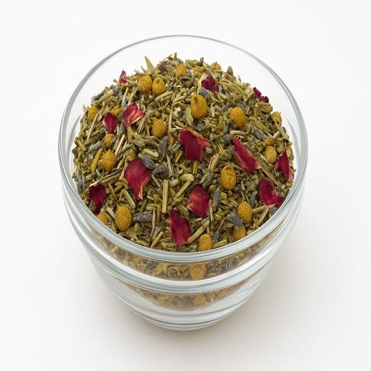 Glass bowl filled with a mix of dried herbs and flowers on a white background